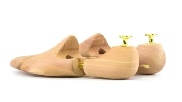 Set of wooden shoe trees with gold accents
